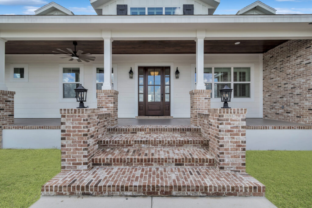 Brick steps leading up the elevated front porch to the front door. Custom Home Builder Ocala Fl
