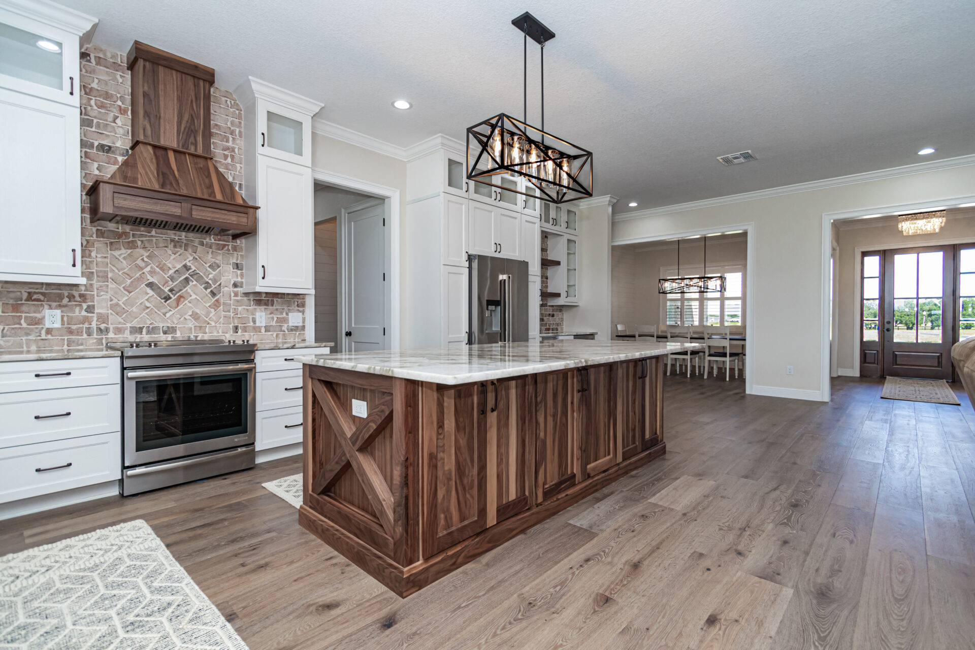 View of the kitchen island with farm house chandelier Luxury Living New Construction Homes