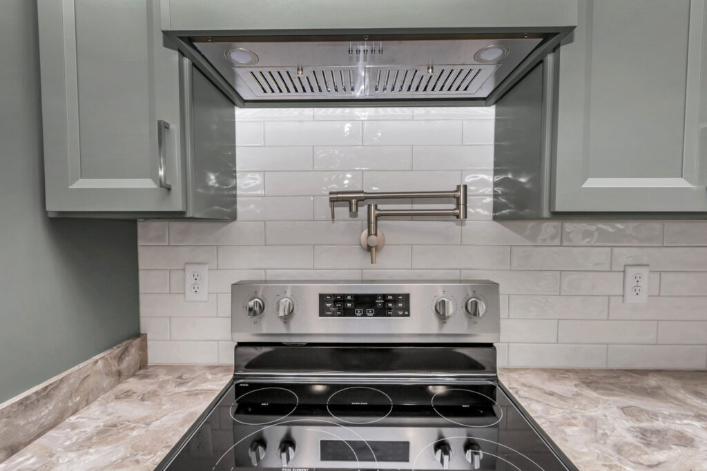 The kitchen's range hood and tiled backsplas