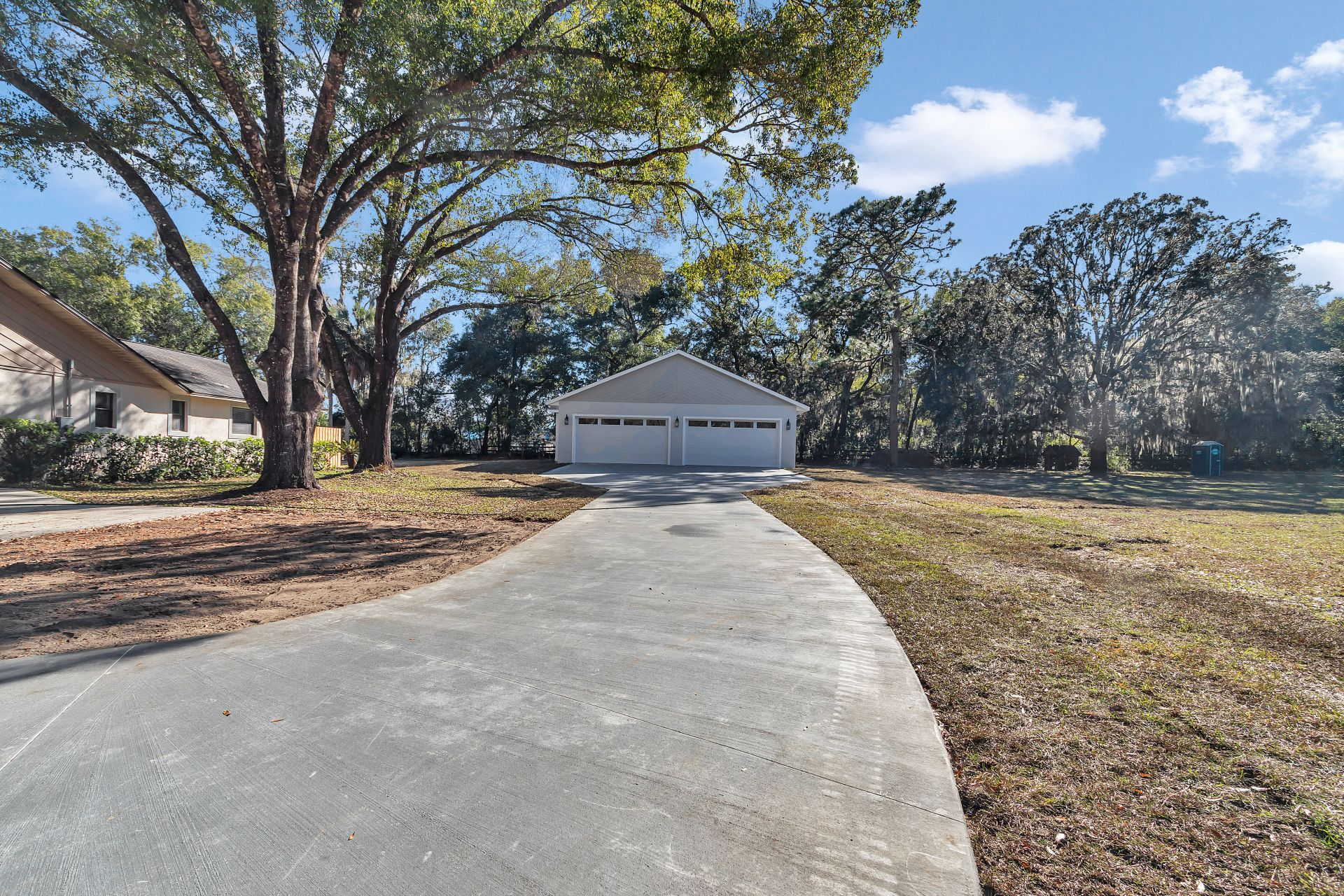 View of the main driveway leading directly to the two-bay garage doors.