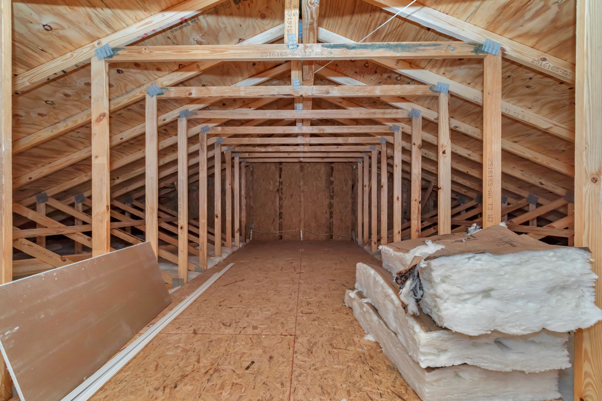 Wide view of the attic interior showing standing-room height and wood beam framing.