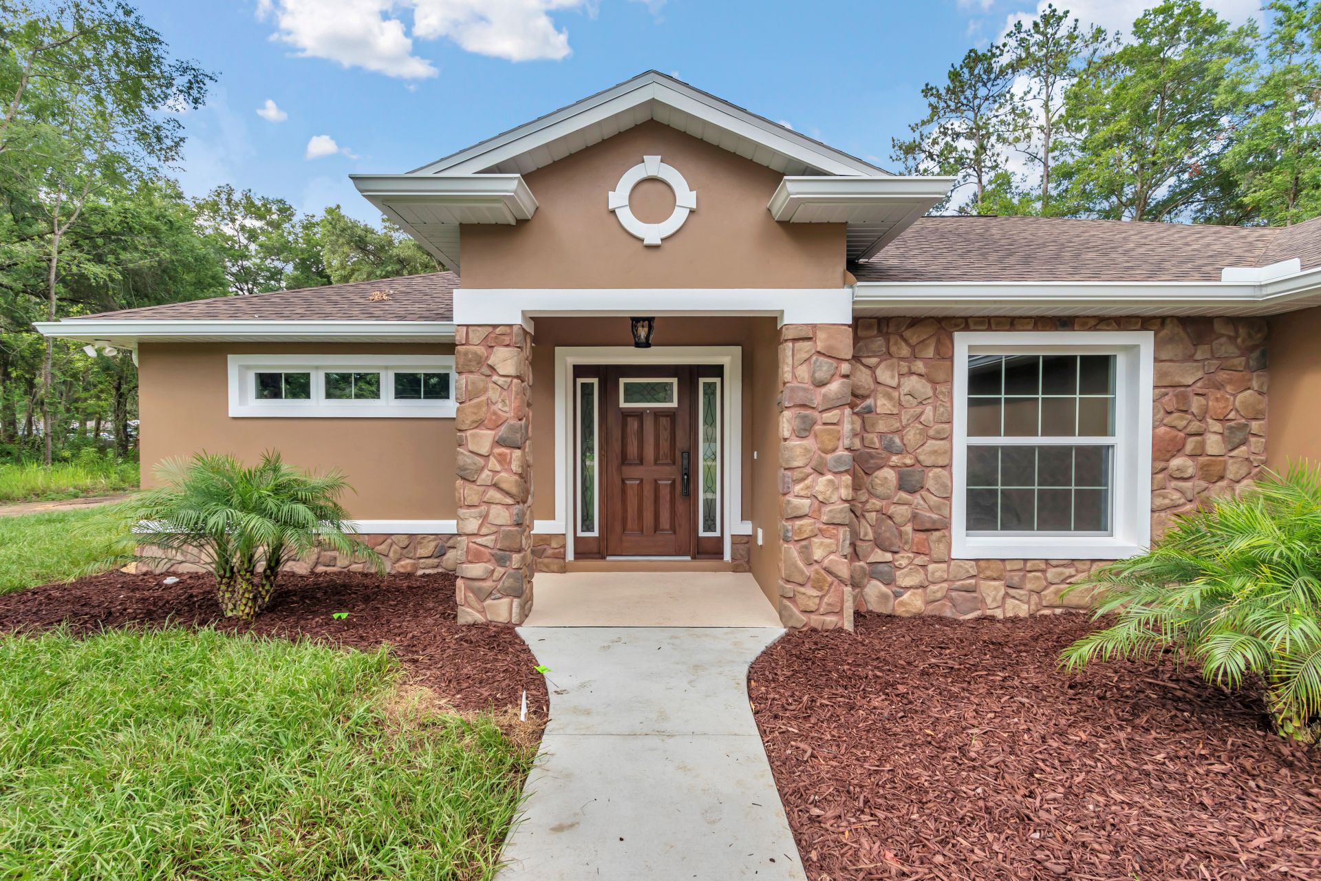 Entrance detail featuring custom fieldstone wainscoting and cherry wood door in Ocala.