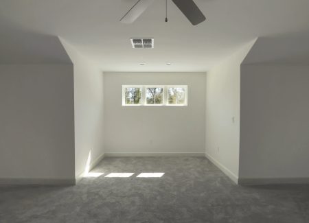 Architectural detail of the attic's indented seating area, featuring three elevated square windows for unique natural lighting.