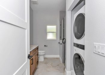 Bathroom with walk-in shower and laundry hookups in the independent living quarters of the French Residence