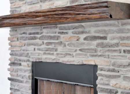 Close-up of the handcrafted multicolor stone fireplace showcasing the quality finishes of the Fort McCoy estate.