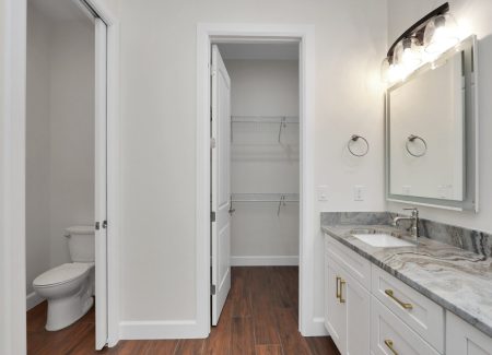 Dedicated toilet room located directly across from the custom double vanity for added privacy