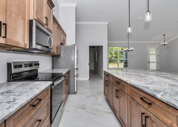 Detailed view of elegant wood cabinets paired with stunning white and grey marble-patterned granite countertops - home designs with mother in law suites