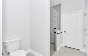 Elegant master bath showcasing custom tile work and a convenient pocket door in an Ocala custom home. - home designs with mother in law suites