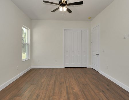 Functional bedroom layout featuring modern sliding closet doors positioned behind the entrance for a space-saving design.