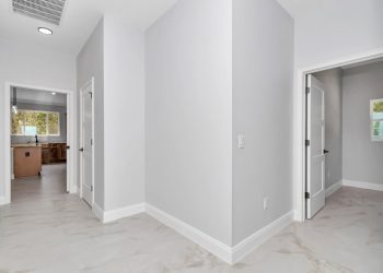 Functional mudroom with hidden pantry and direct garage access, designed by Ocala home builders for the French Residence 1