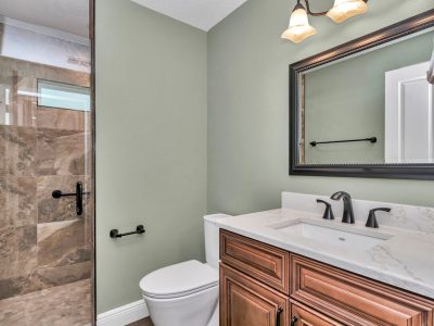 Guest bathroom in Ocala custom home featuring a stand-up shower with a tall, modern shower door