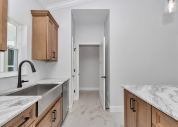 Independent kitchen with stainless steel farm house sink, part of the mother-in-law suite design in Ocala's French Residence.