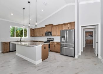 Modern kitchen with wood cabinets, granite island, and cathedral ceilings - home designs with mother in law suites
