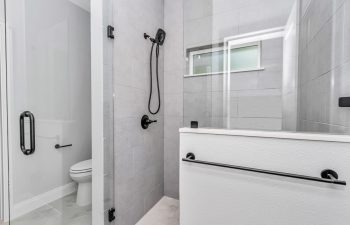 Modern walk-in shower with stylish half-wall and glass enclosure in model 2616; guest bathroom. - home designs with mother in law suites