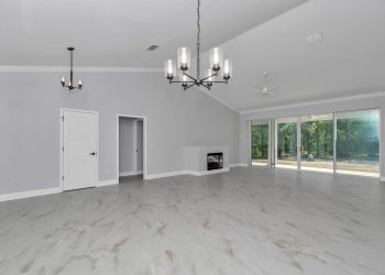 Open concept living and dining area in this Ocala custom home, highlighting the spacious layout and natural light - home designs with mother in law suites