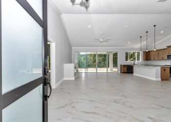 Open concept living space in French Residence, highlighting elegant crown molding and light-filled interiors - home designs with mother in law suites