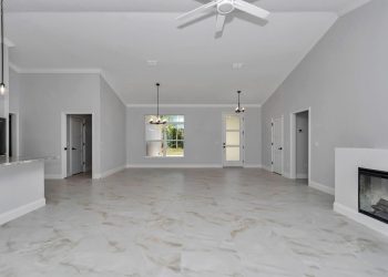 Panoramic view from the great room showing the open-concept kitchen and dining area in the French Residence, an innovative Ocala home design. - home designs with mother in law suites