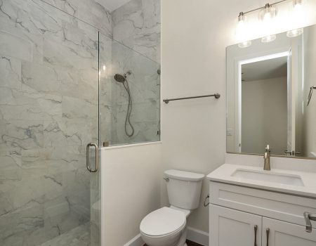 Private en-suite bathroom featuring a custom walk-in shower with floor-to-ceiling granite walls.