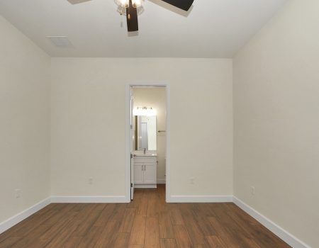 View from the bedroom area into the private third bathroom, highlighting the consistent modern trim and neutral color palette