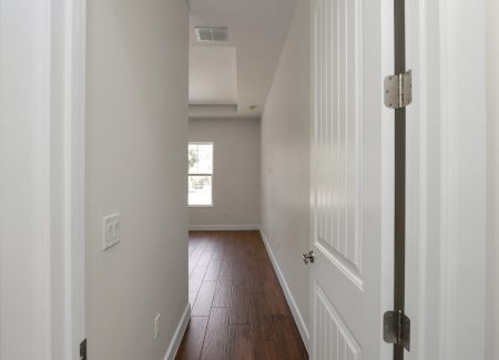 View through the open primary bedroom door, revealing the spacious master suite of the Fort McCoy custom home.