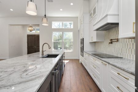 White and grey granite countertops spanning the custom blue island and the main kitchen workspaces.
